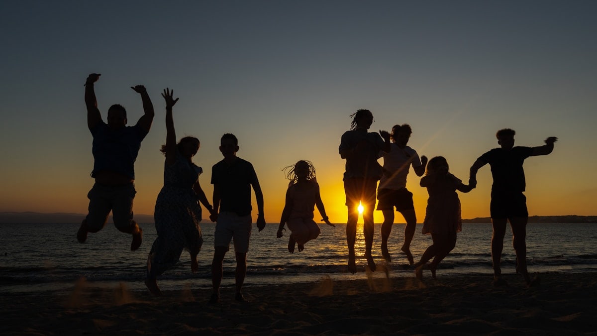 Family jumping sunset on a beach